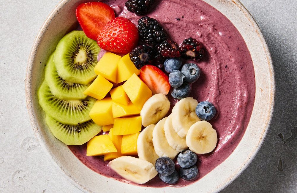 Tigela de açaí montada com morango, mirtilo, manga e granola